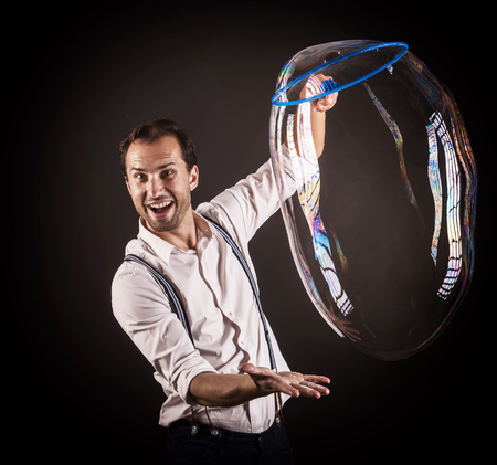 Artist hold big soap bubble in his hands. Bubble show studio concept.の写真素材