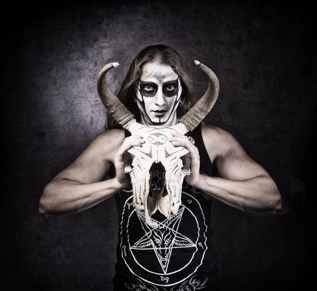 Portrait of man in goth style clothes with skull in his hand.の写真素材