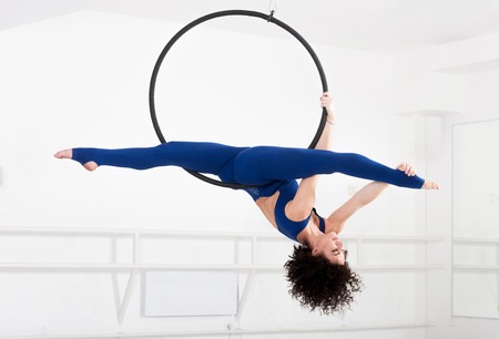 Woman hanging in aerial ring, isolated on whiteの写真素材