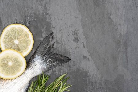 Fresh fish dorado. Dorados tail and ingredients for cooking on a concrete background.の写真素材