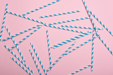 Striped coctail straws on pink background. Birthday party celebration abstract fashion baby shower...