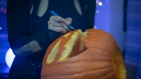 Girl cutting a halloween pumpkin to make a faceの写真素材