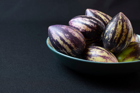 Eggplant in a bowl on a black background with copy spaceの写真素材