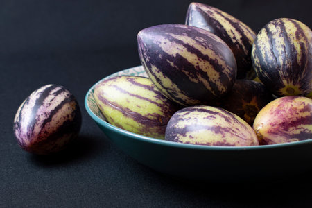 Ripe purple eggplants in a bowl on a black backgroundの写真素材