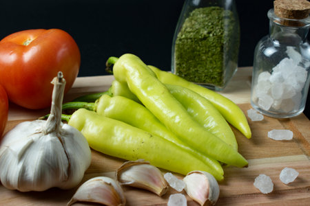 Fresh vegetables and spices on a wooden board. On a black background.の写真素材