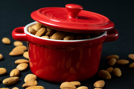 Closeup of a red casserole with almonds on black backgroundの写真素材