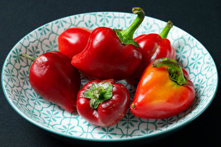 Red and yellow bell peppers in a plate.の写真素材
