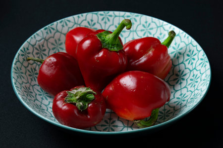 Red hot chili peppers on a plate on a black background, close-upの写真素材