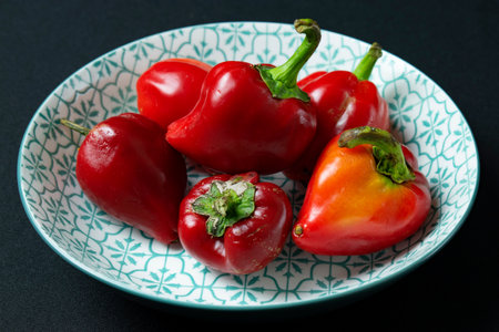 Red peppers in a plate on a black background. Selective focus.の写真素材