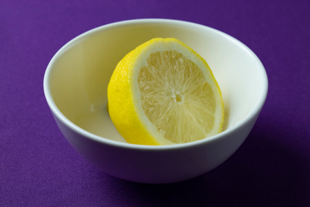 Lemon in a bowl on a purple background, close-upの写真素材