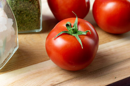 Tomatoes and salt on a cutting board. Ingredients for cooking.の写真素材