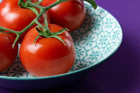Cherry tomatoes in a bowl on a purple background. Close up.の写真素材