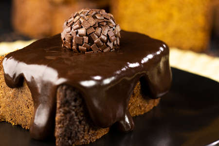 Carrot cake with chocolate cream and brigadeiro on a black plate - delicious dessertの写真素材