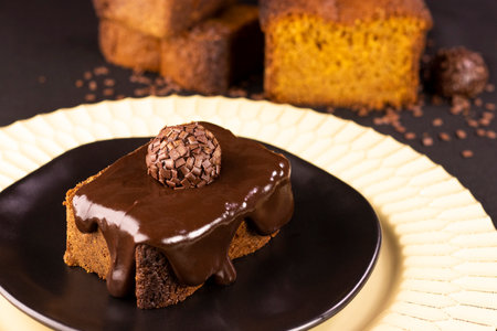 Carrot cake with chocolate cream and brigadeiro on a black plate - delicious dessertの写真素材