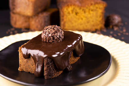 Carrot cake with chocolate cream and brigadeiro on a black plate - delicious dessertの写真素材
