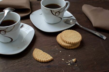 cups with coffee and cookies