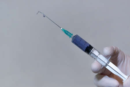 Close-up of a Medical Syringe With a Vaccine expelling liquid No Logo - Translation: for one-time...