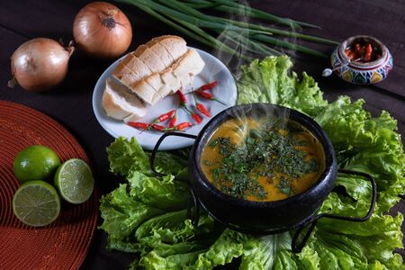 pumpkin broth with bread and pepper on a rustic table. Brazilian food.