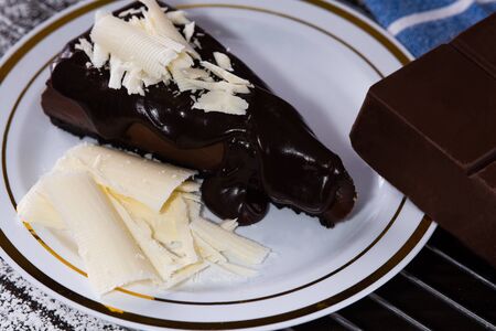 Chocolate pie on a white plate and with a chocolate bar next to it.