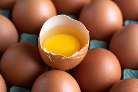 Chicken eggs broken in the middle of other eggs.