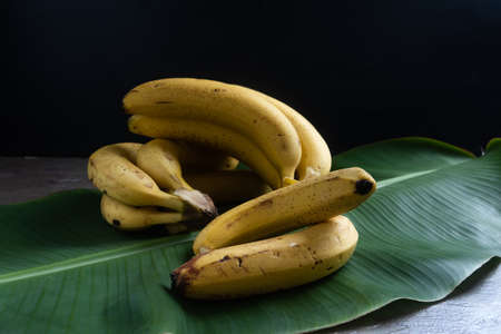 banana on top of banana leaf on brown rustic background.の写真素材