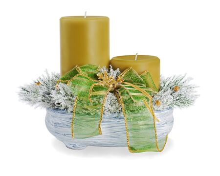 Christmas composition of two candles, ornaments and pine branches in a ceramic vase isolated on white backgroundの写真素材