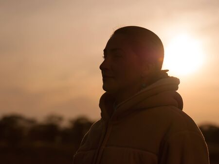 Outdoor fashion closeup portrait of pretty young woman. Woman posing in autumn sunny sunset.の写真素材