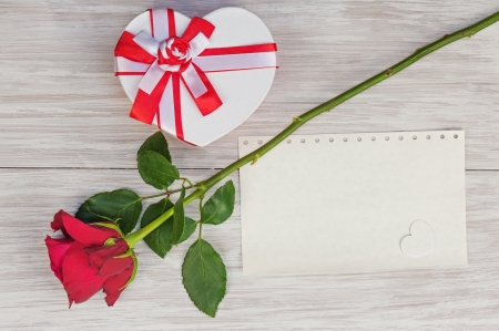 Valentine`s Day gift, rose and paper on wooden background. Closeup.の写真素材