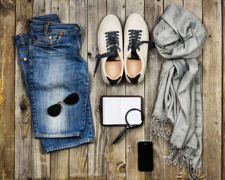 Set of travel items including scarf, sunglasses, sneakers, note book, magnifying glass, mobile phone...