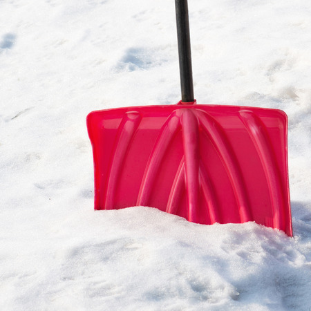Red plastic shovel for snow removal.の写真素材