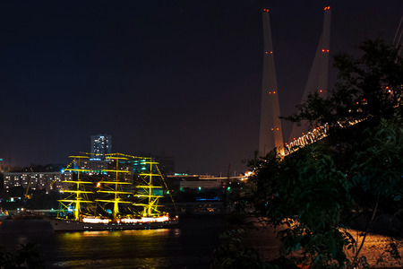 Night view on the sailboat near the bridge in the Russian Vladivostok over the Golden Horn bay.