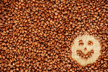 Face coffee frame made of coffee beans on burlap texture.の写真素材