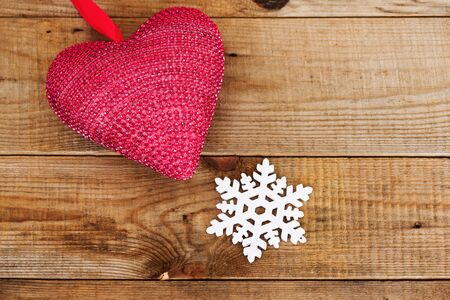 Red heart and snowflake on wooden background. Winter and Christmas concept.の写真素材