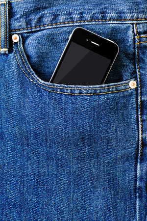Modern smart phone in front pocket of blue denim jeans. Closeup.の写真素材
