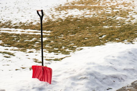 Red plastic shovel for snow removal. Winter concept.の写真素材