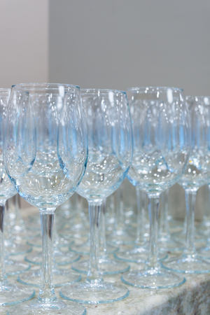 Lot of clear empty wine glasses on granite stone table and grey background. Selective focusの写真素材