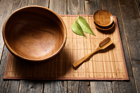 Empty wooden bowl with accessories on natural background. Selective focus.の写真素材
