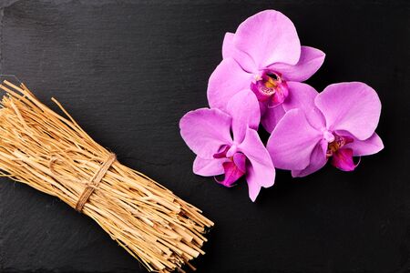 Flower arrangement of orchids on dark stone background.の写真素材