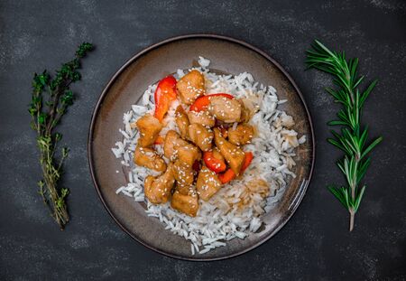 Tasty rice with chicken, rosemary and thyme on black background top view.の写真素材