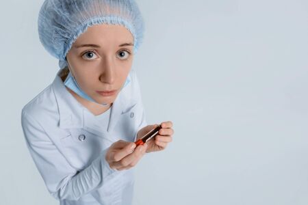 Doctor with blood sample for Coronavirus testing looks at you with concern. Epidemic Middle East Respiratory Syndrome  2019-nCoV.の写真素材