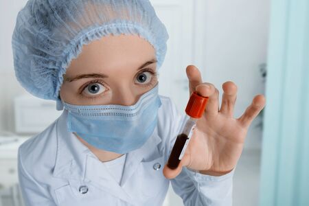 Doctor in hospital looks at you scared. Positive blood sample for Coronavirus testing.の写真素材