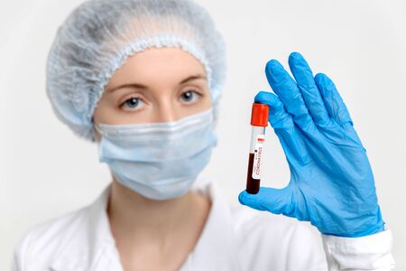 Isolated nurse wearing medical mask holds test tube with blood sample for Coronavirus testing. Epidemic Middle East Respiratory Syndromeの写真素材
