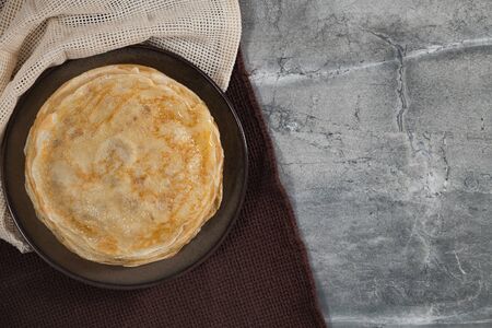 A stack of pancakes on the marble table for Maslenitsa. Holiday breakfast.の写真素材