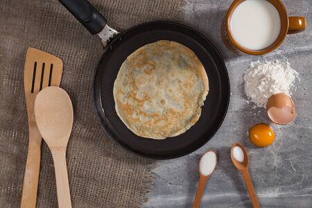 Cooking pancakes for Maslenitsa breakfast. A pancake on hot pan with ingredients.の写真素材