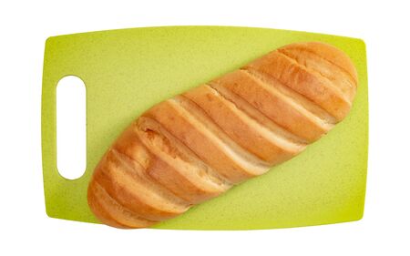 Isolated loaf of bread on green cutting board on white background top view.の写真素材