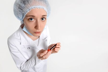 Isolated nurse on white background with blood sample for Coronavirus testing looks at you with empathy. Epidemic Middle East Respiratory Syndrome, 2019-nCoV.の写真素材