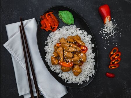 Chinese dish rice with chicken with chopsticks on black background top view.の写真素材
