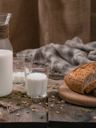 Milk and whole wheat bread on an old planked table.の写真素材