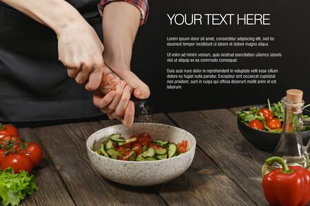 Woman cooking fresh vegetable salad on wooden table. Healthy diet lifestyle.の写真素材