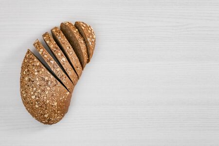 Bread with seeds and flakes on white background top view.の写真素材